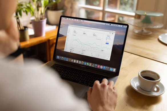 Laptop zeigt Performance Dashboard, daneben steht eine Kaffeetasse.