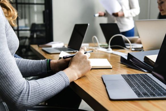 Frau sitzend am Schreibtisch mit Laptop