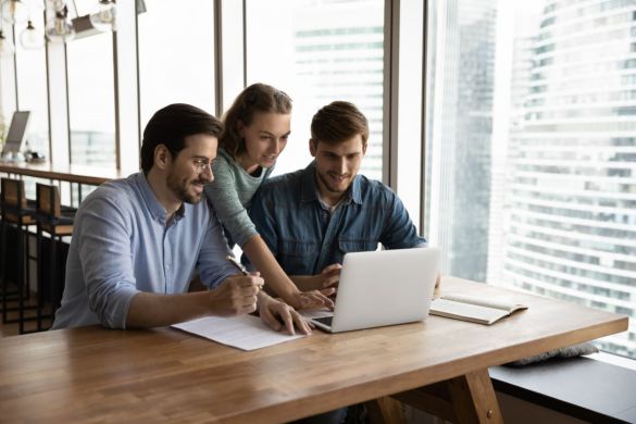 3 Personen arbeiten zusammen an einem Laptop